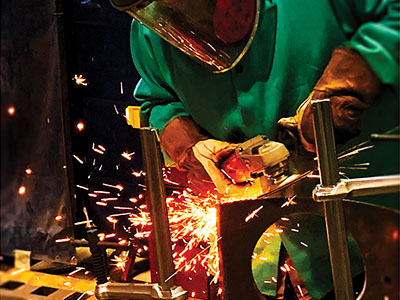 Employee grinding metal
